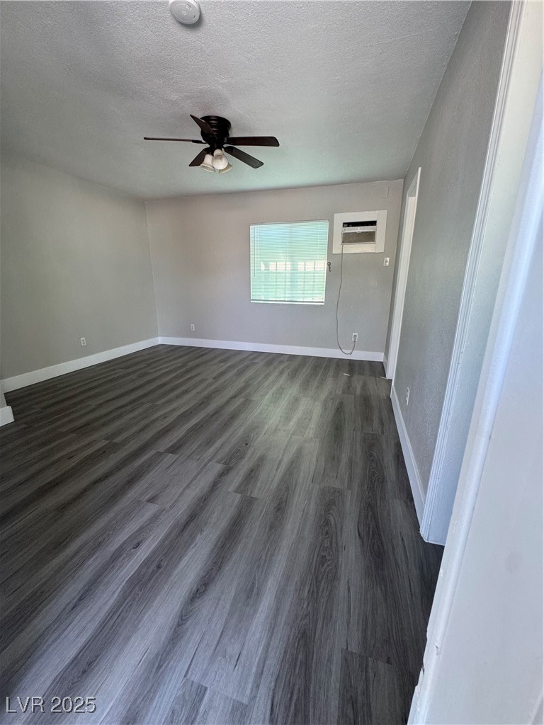 640 North 9th Street, Unit 3 Las Vegas, NV 89101 - Photo 3 of 11 Empty room with a textured ceiling, dark wood finished floors, a ceiling fan, a wall mounted AC, and a smoke detector