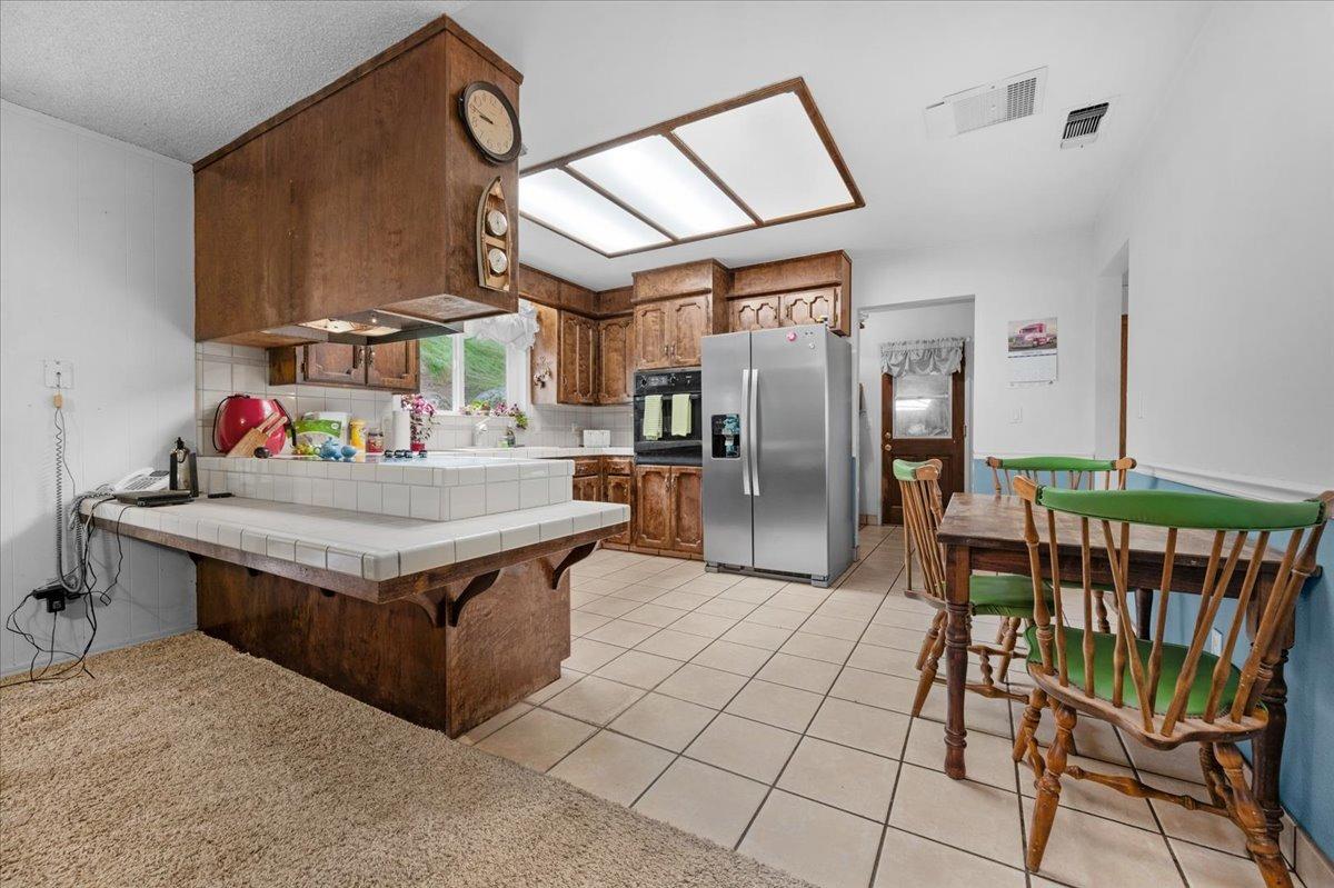 46473 Konklin Road Coarsegold, CA 93614 - Photo 11 of 38 a kitchen with stainless steel appliances granite countertop a stove a refrigerator and a dining table