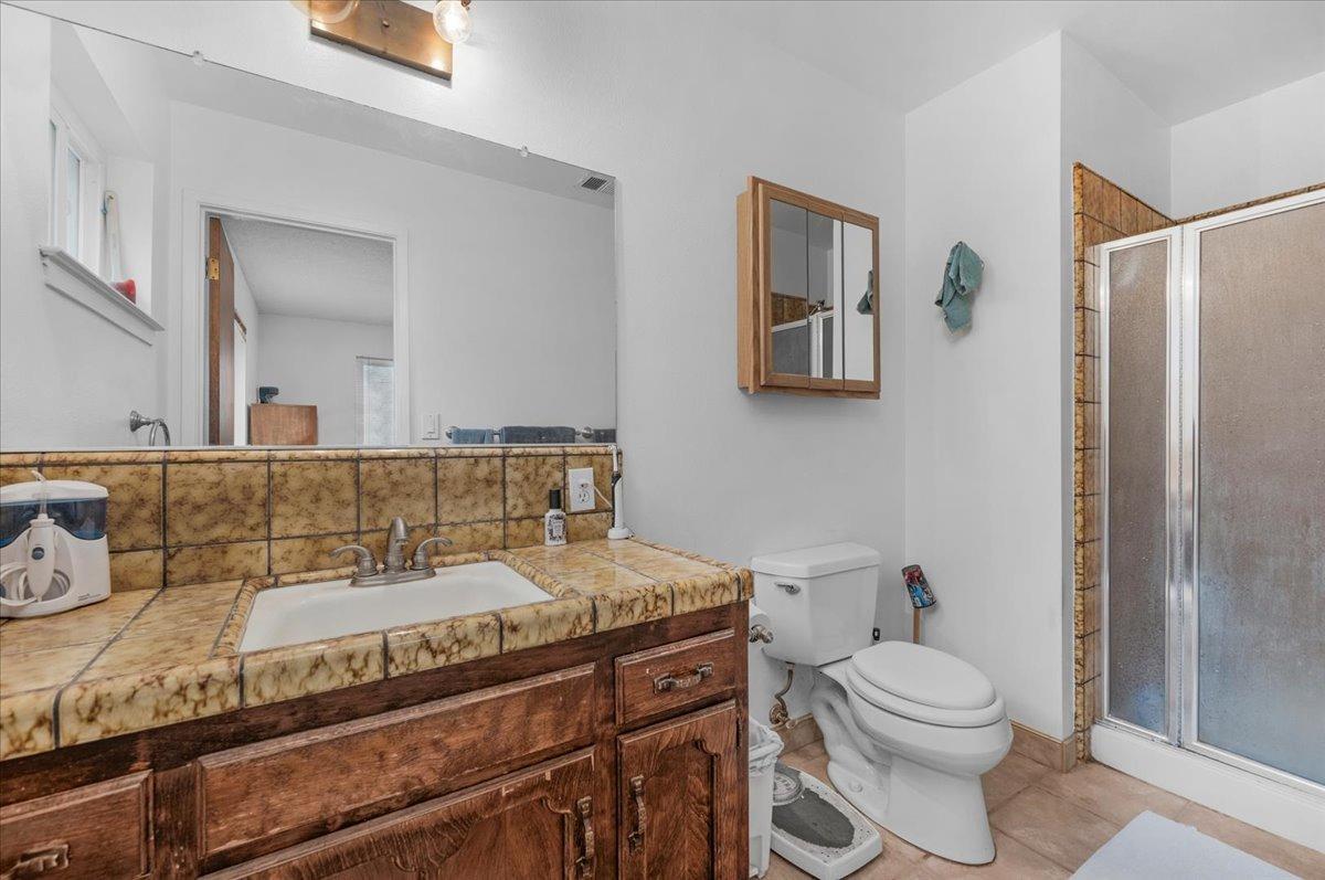 46473 Konklin Road Coarsegold, CA 93614 - Photo 22 of 38 a bathroom with a granite countertop toilet sink and mirror