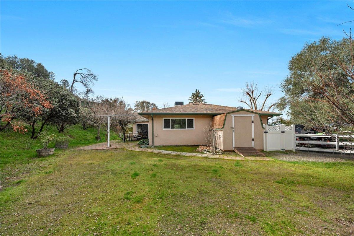 46473 Konklin Road Coarsegold, CA 93614 - Photo 28 of 38 a white house with a big yard and large trees with wooden fence