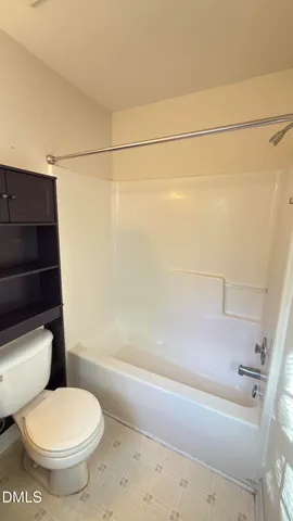 a white toilet sitting next to a bath tub and a shower