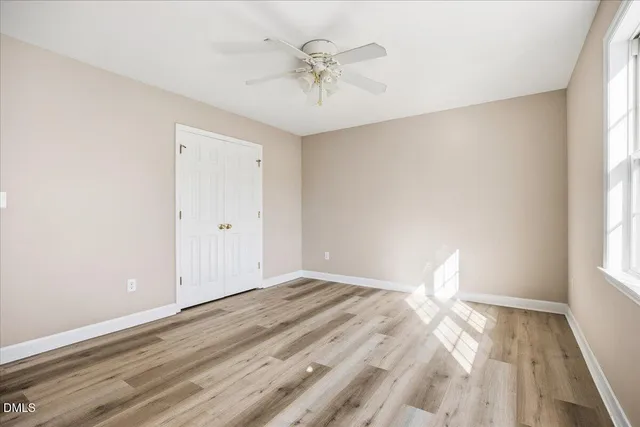 a view of a livingroom with a window and wooden floor