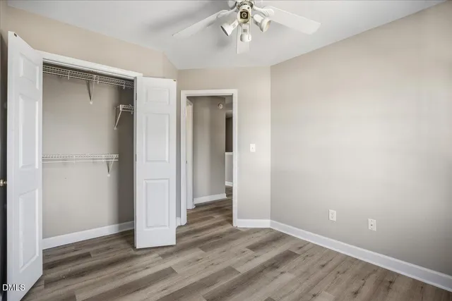 an empty room with wooden floor and hallway