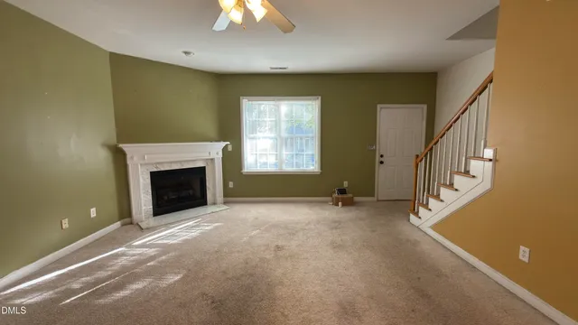 a view of an empty room with a fireplace and a window