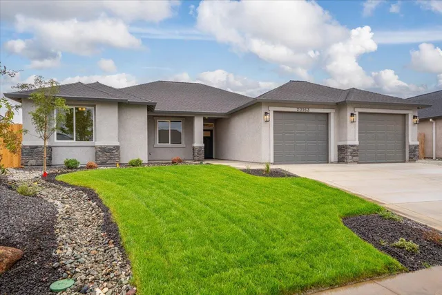 a front view of a house with a garden and yard
