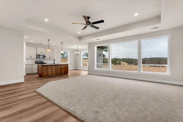 a large kitchen with stainless steel appliances kitchen island granite countertop a refrigerator a stove a sink dishwasher with a dining table and chairs with wooden floor