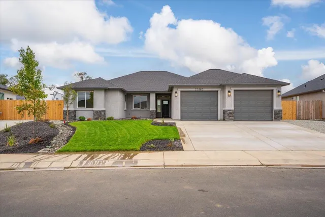 a front view of a house with a garden and plants