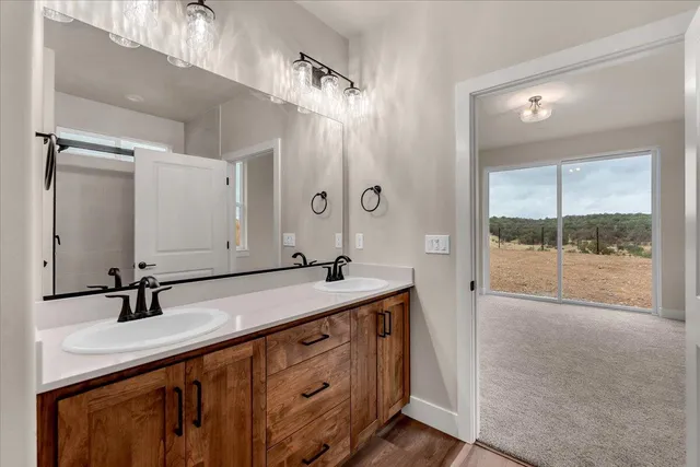 a bathroom with a double vanity sink and mirror with shower