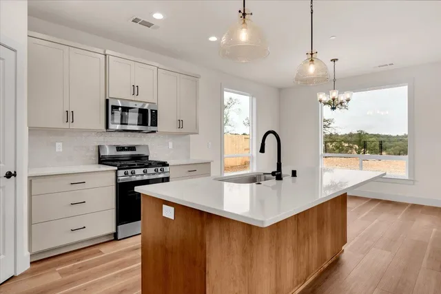 a kitchen with kitchen island a sink stove and wooden floor