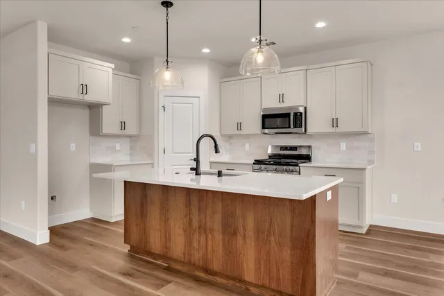 a kitchen with kitchen island a sink stainless steel appliances and cabinets