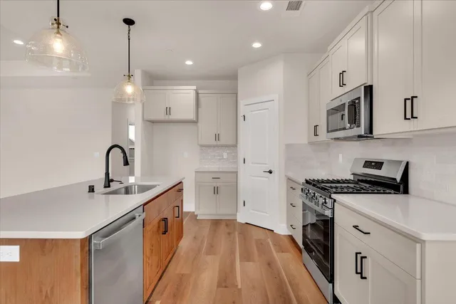 a kitchen with stainless steel appliances granite countertop a sink stove and refrigerator