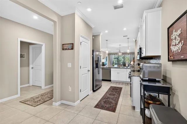 a kitchen with kitchen island granite countertop a sink a stove a dining table and chairs