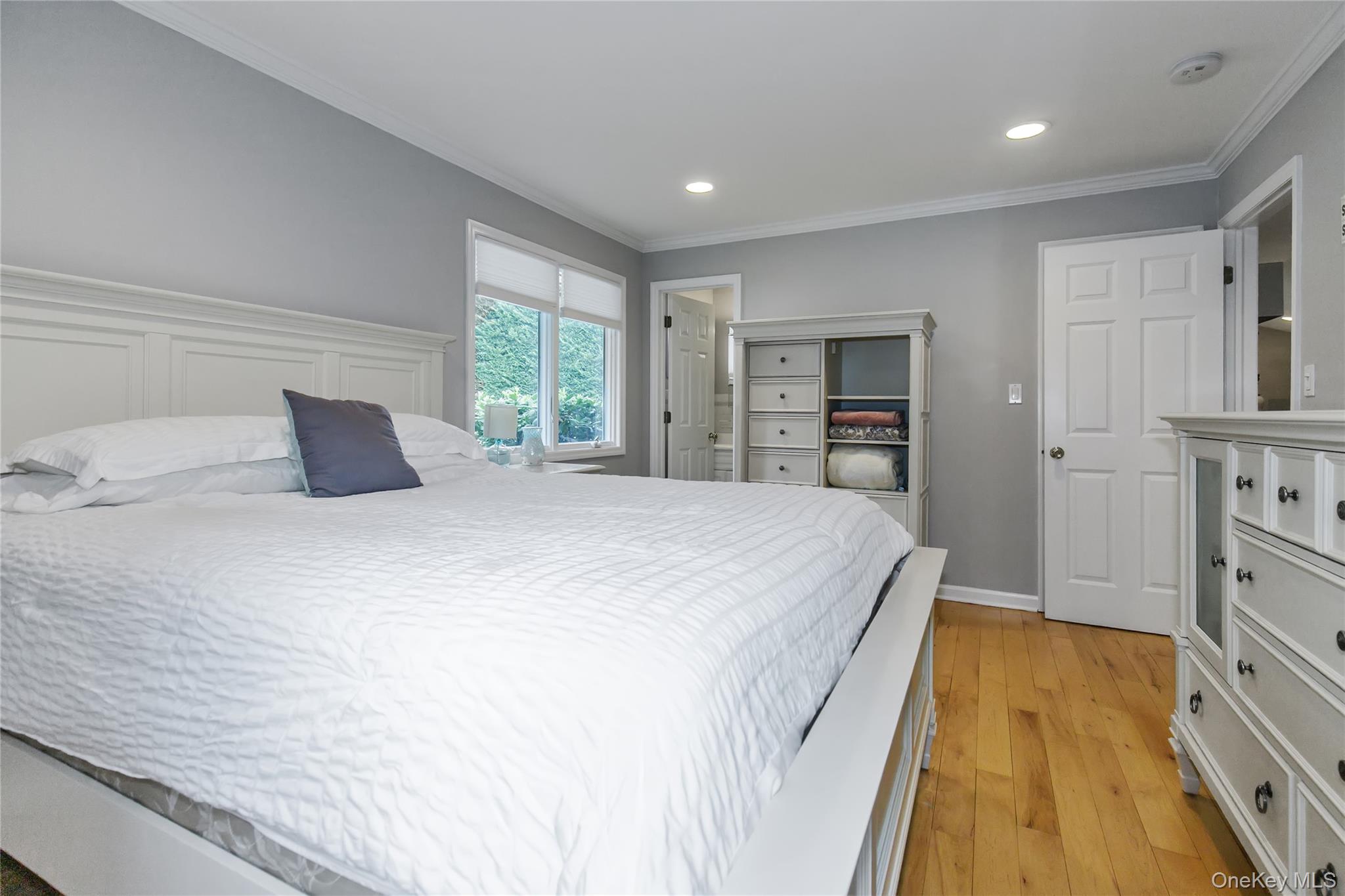 5 Searington Drive Syosset, NY 11791 - Photo 18 of 34 a spacious bedroom with a bed and a couch