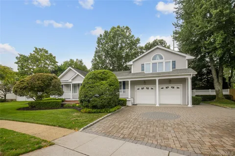 a front view of a house with a yard and trees