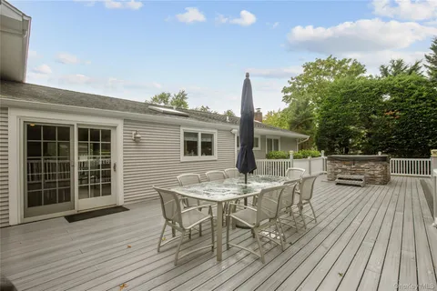 a view of a roof deck with table and chairs and wooden floor