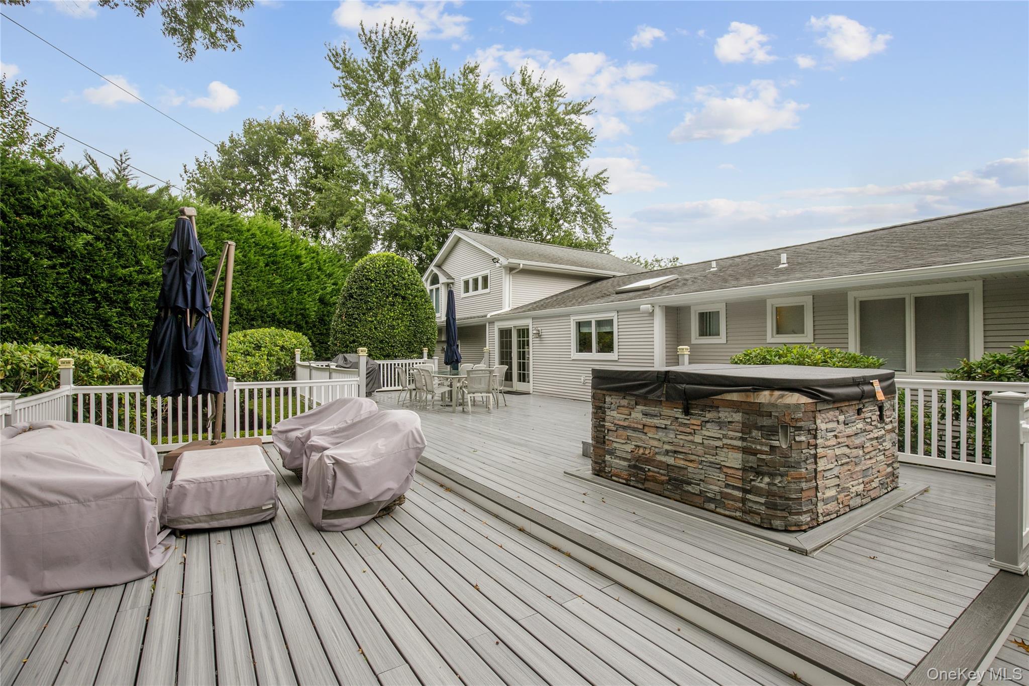 5 Searington Drive Syosset, NY 11791 - Photo 32 of 34 a view of a chair and tables the back yard of the house