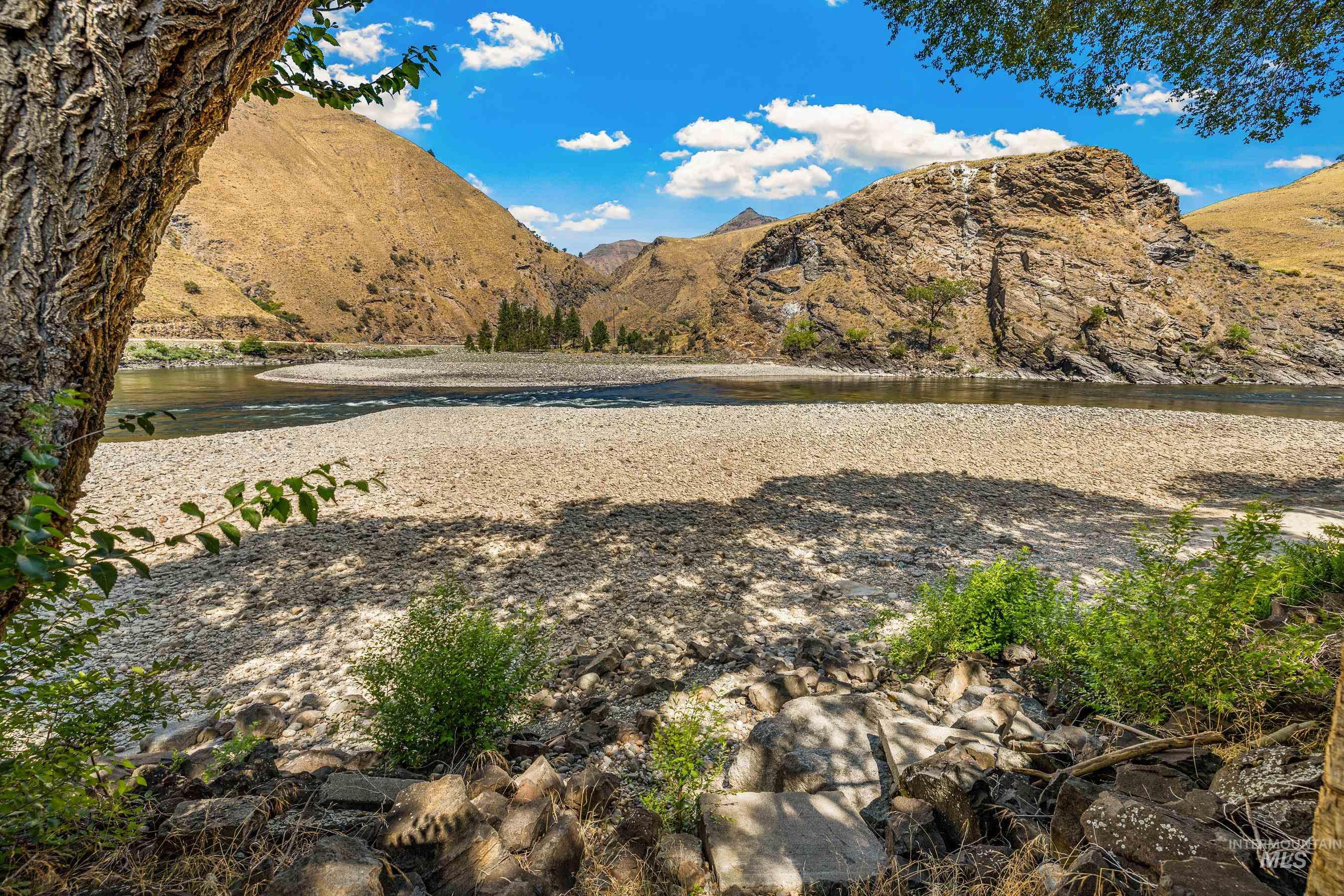 1432 Salmon Drive Riggins, ID 83549 - Photo 4 of 39 Riverfront setting featuring a wide gravel bank, flowing water, and surrounding mountains