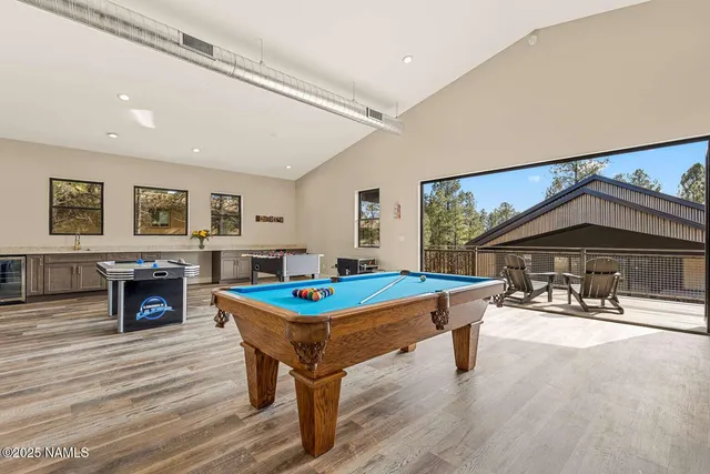 a living room with furniture a pool table and a fireplace