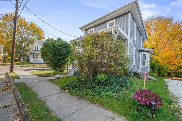 a front view of a house with a yard and fountain