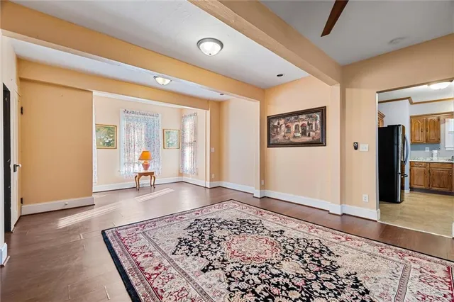 a view of a hallway with wooden floor and windows