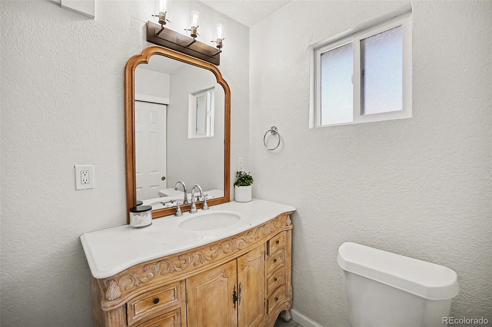 8207 High Street Denver, CO 80229 - Photo 15 of 31 a bathroom with a sink vanity and a toilet