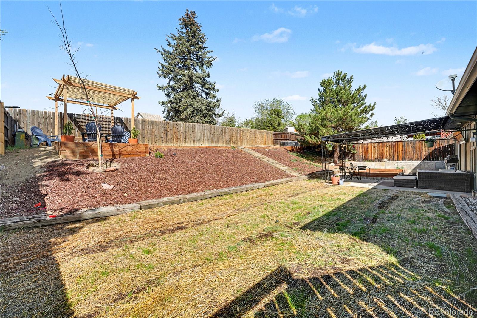 8207 High Street Denver, CO 80229 - Photo 17 of 31 a backyard of a house with table and chairs