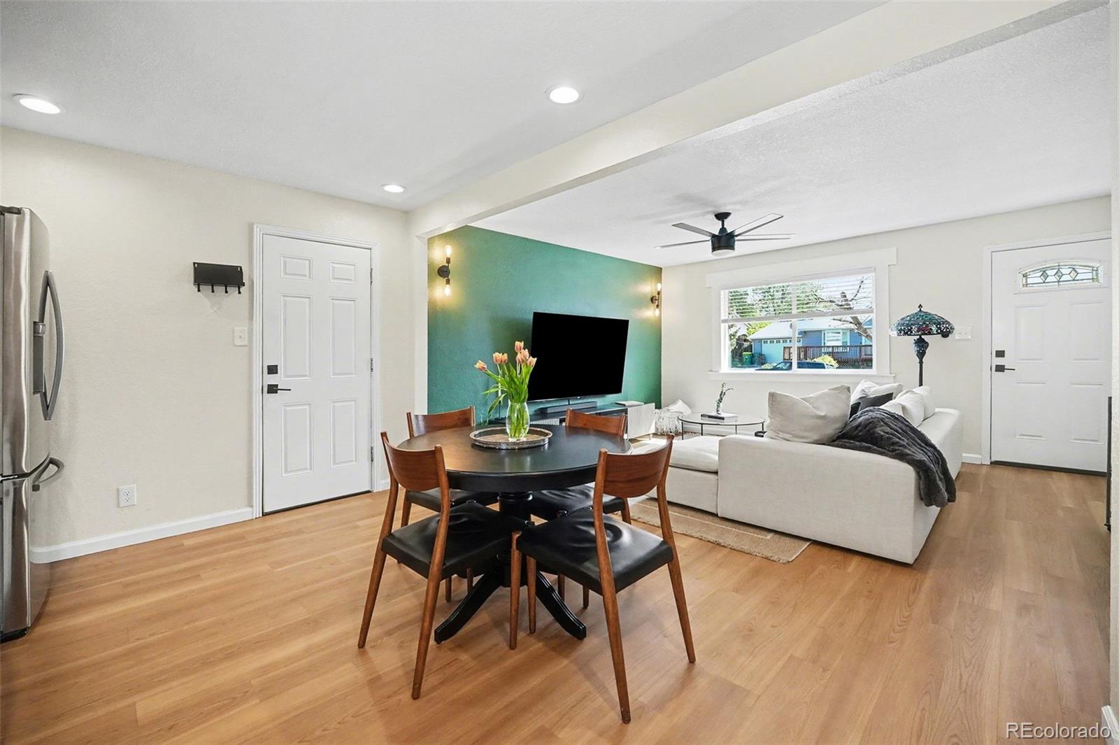 8207 High Street Denver, CO 80229 - Photo 7 of 31 a living room with furniture a flat screen tv and a wooden floor