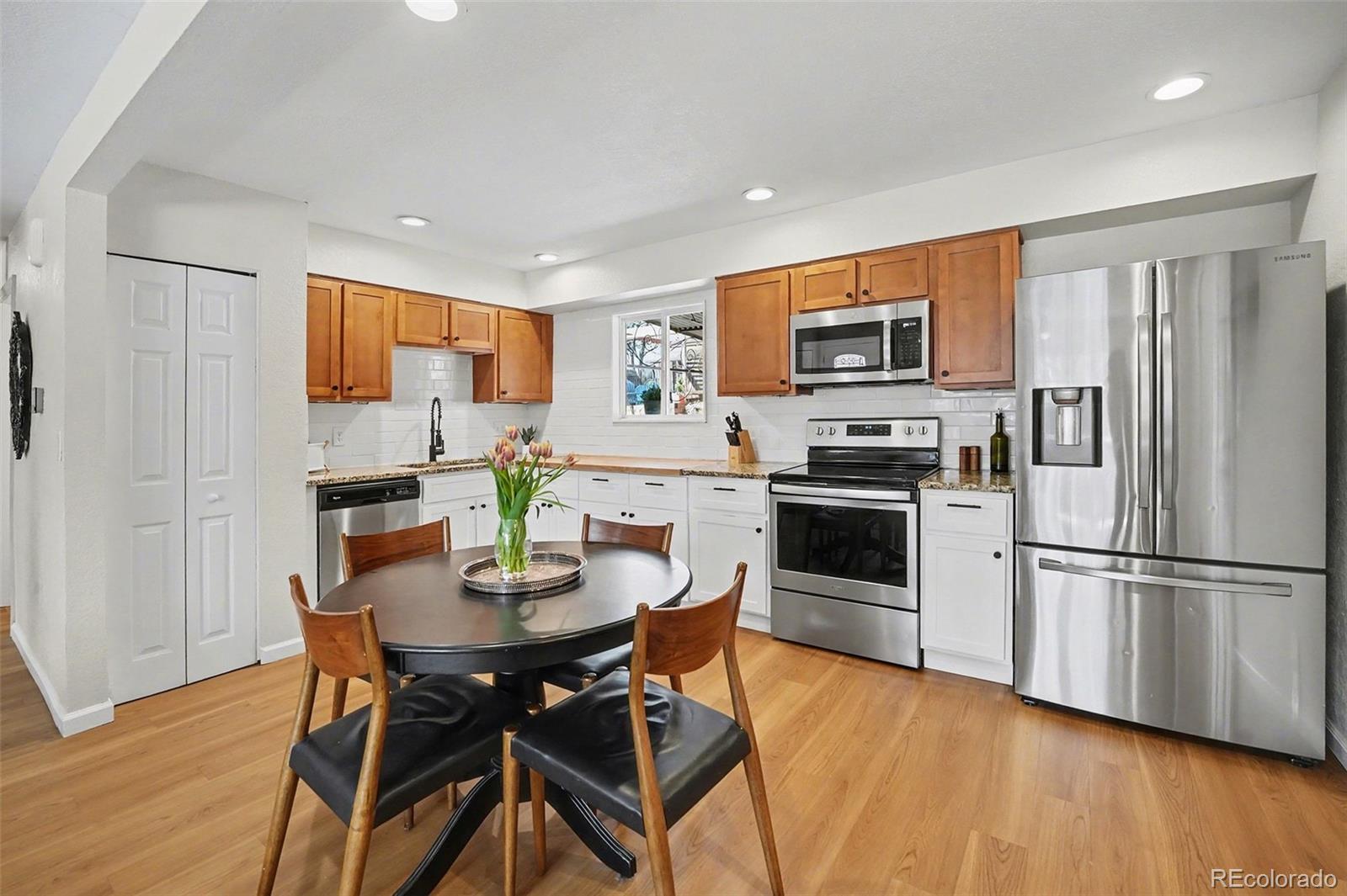 8207 High Street Denver, CO 80229 - Photo 8 of 31 a kitchen with stainless steel appliances a refrigerator and a stove top oven