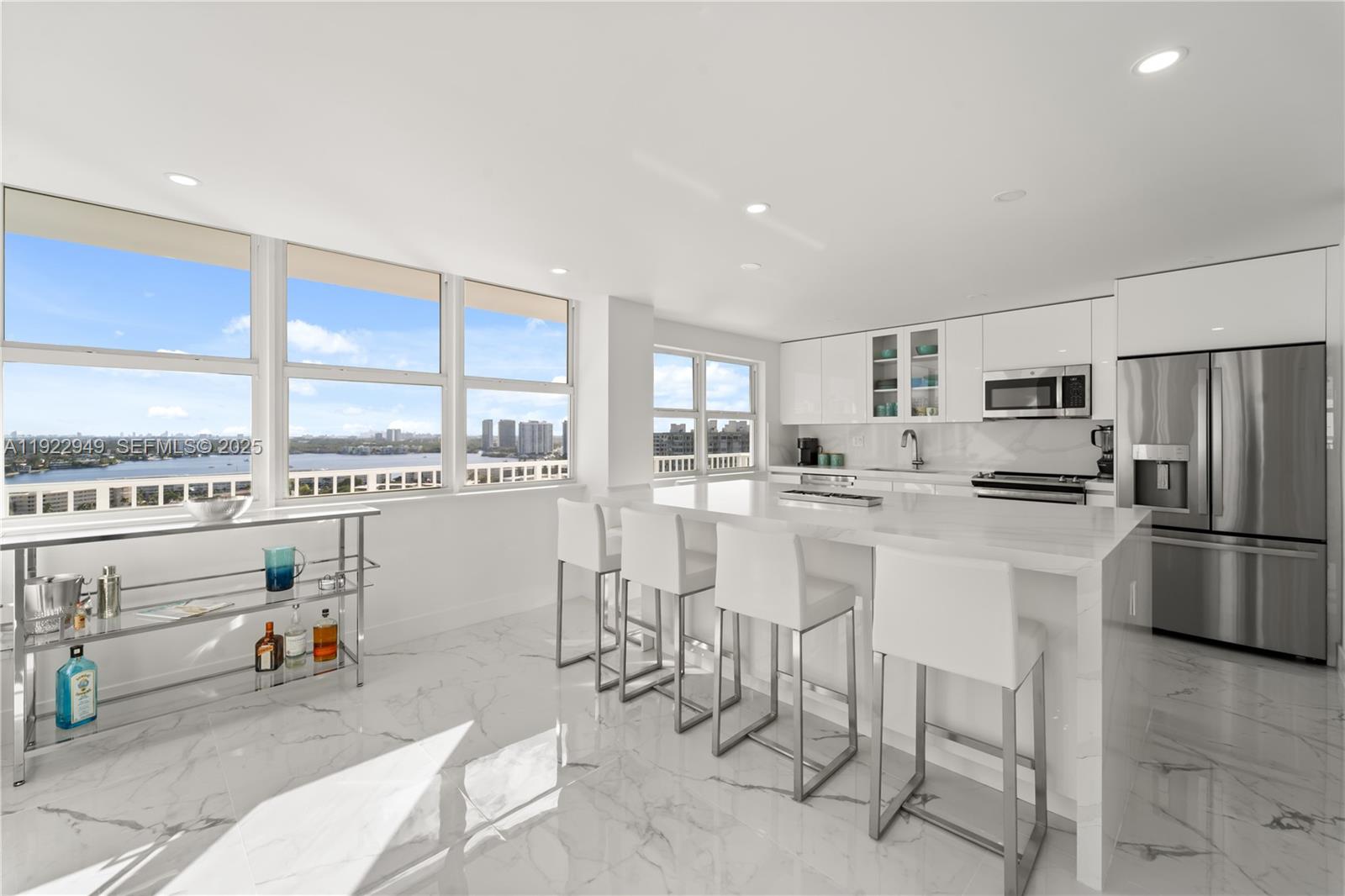 2801 Northeast 183rd Street, Unit 2116W Aventura, FL 33160 - Photo 6 of 23 a kitchen with stainless steel appliances a refrigerator a stove a sink dishwasher and a dining table with wooden floor