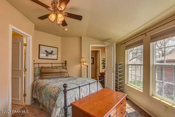 a bedroom with a large bed a chandelier and a window