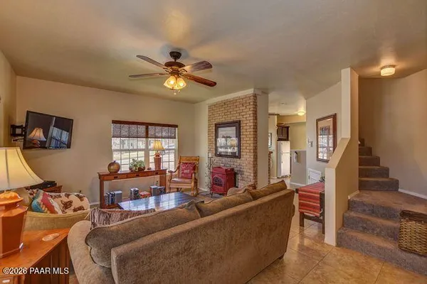 a living room with furniture a ceiling fan and a window