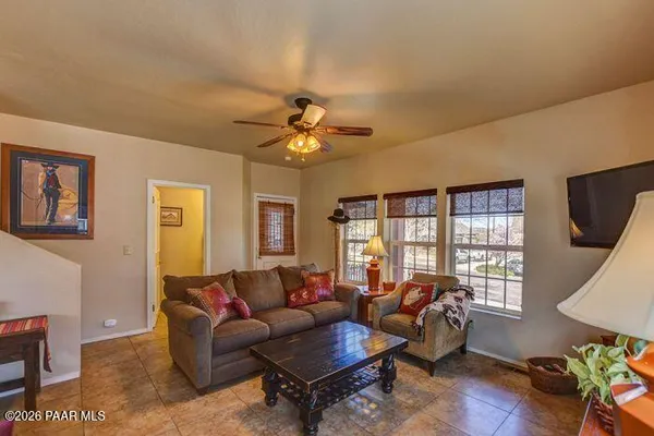 a living room with furniture a flat screen tv and a window