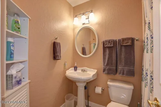 a bathroom with a toilet sink and mirror