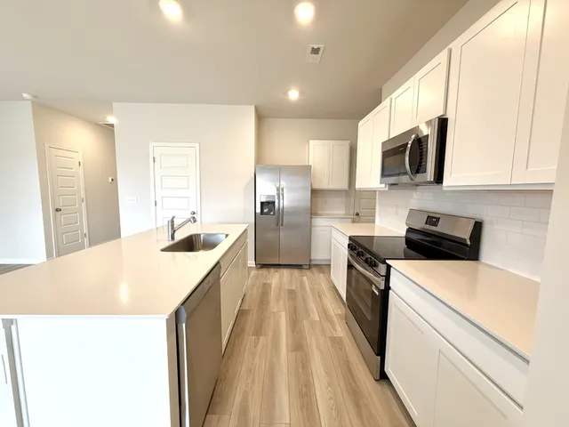a kitchen with a sink a stove top oven and white kitchen