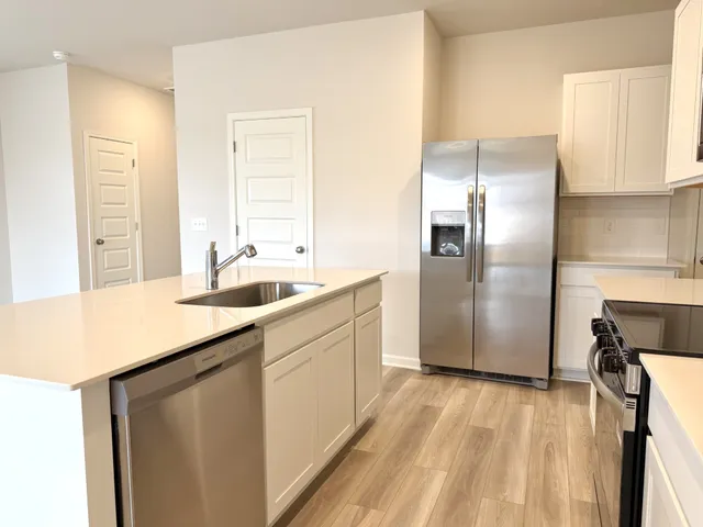 a kitchen with stainless steel appliances a sink stove and refrigerator