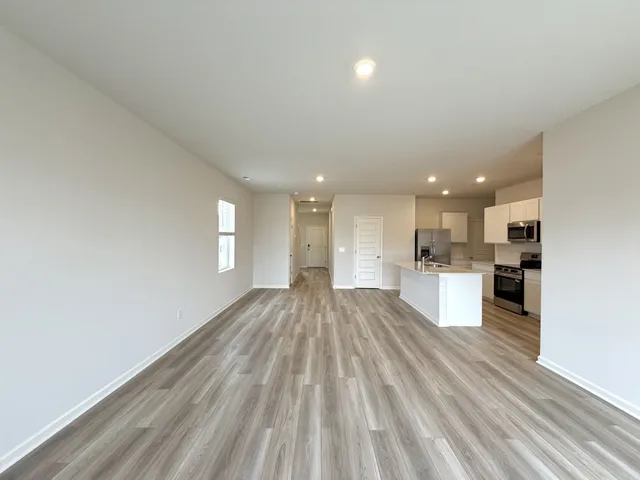 a view of kitchen view wooden floor and stainless steel appliances