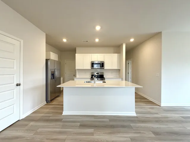 a view of kitchen with stainless steel appliances granite countertop a stove top oven