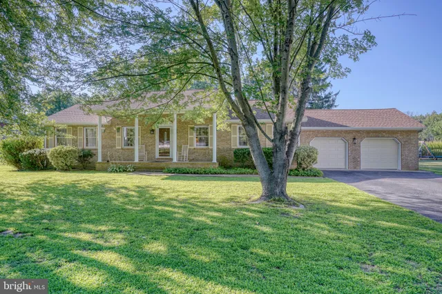 a house with a big yard and large trees