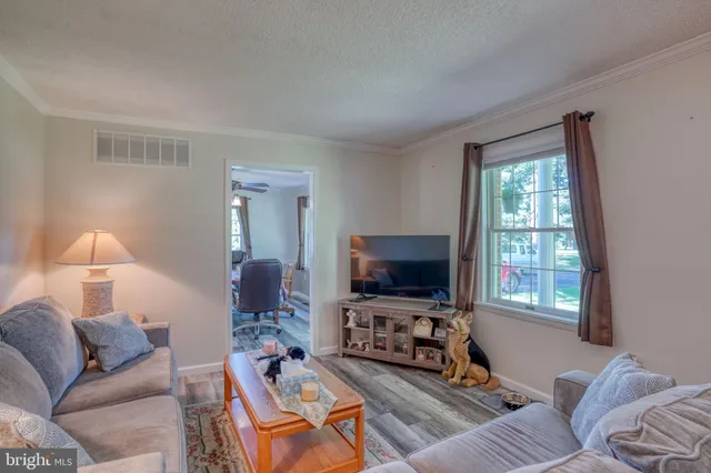 a living room with furniture a flat screen tv and a window