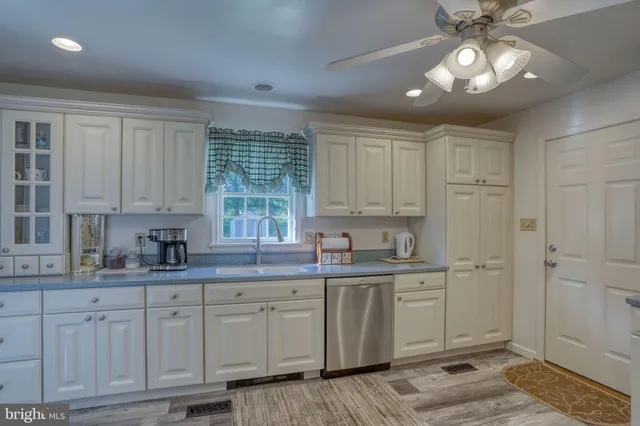 a kitchen with kitchen island granite countertop a sink cabinets and window