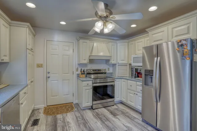 a kitchen with stainless steel appliances a stove a refrigerator and a sink