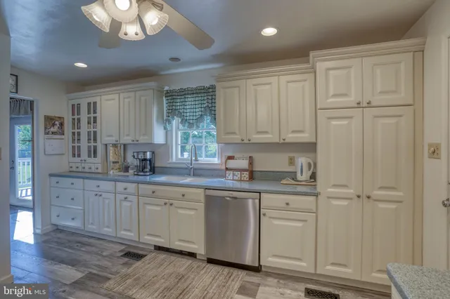 a kitchen with white cabinets and sink