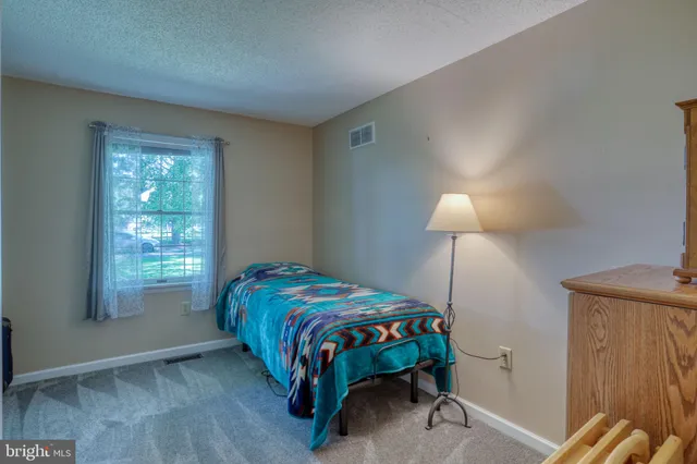 a bedroom with a bed and a lamp