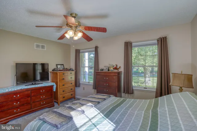 a bedroom with a bed and a flat tv screen on dresser