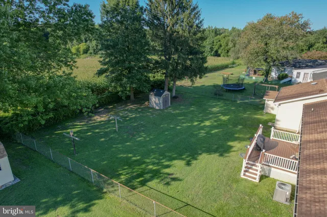 a view of backyard with swimming pool and green space