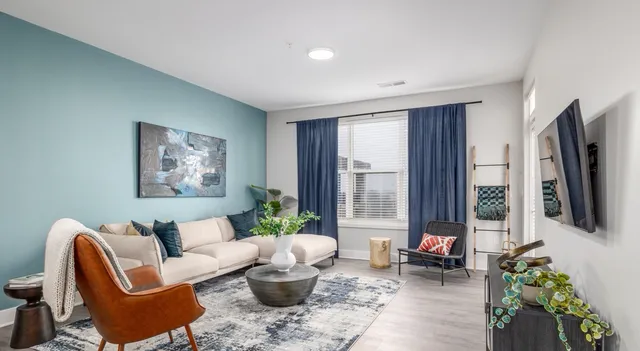 a living room with furniture floor to ceiling window and a flat screen tv