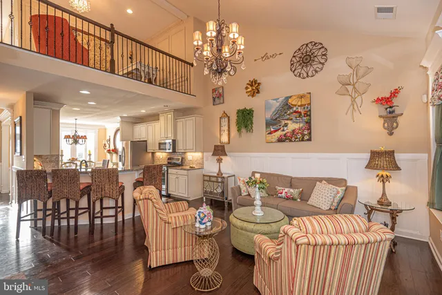 a kitchen with stainless steel appliances kitchen island granite countertop a refrigerator a stove a microwave oven with white cabinets and wooden floor