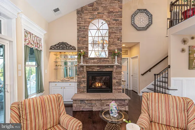 a living room with fireplace furniture and a large window