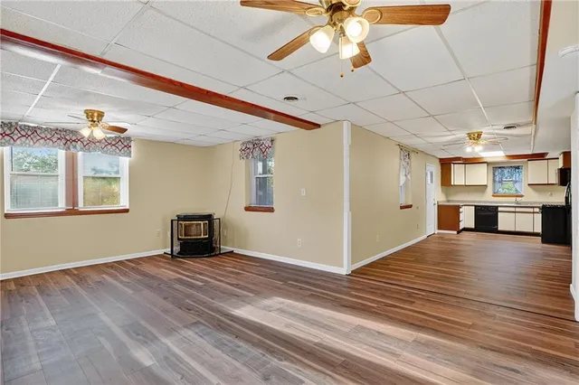 a view of an empty room with window and wooden floor