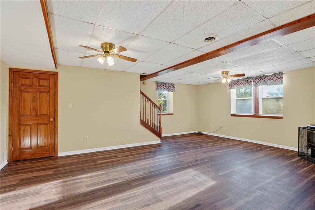 208 McCleary Road Aliquippa, PA 15001 - Photo 13 of 45 an empty room with wooden floor chandelier fan and windows